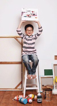 의자 위에 앉아 책을 들고있는 남자아이