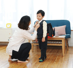 아이옷을 입히는 여성과 남자아이